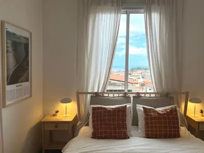 a bedroom with a bed with a large window at Madeira Breeze in Funchal