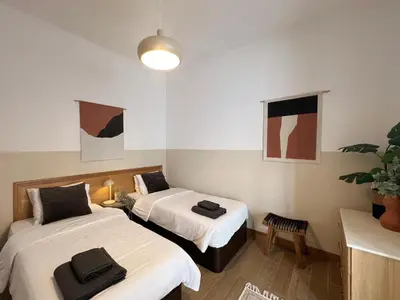 a room with two beds and a potted plant at Madeira Breeze in Funchal
