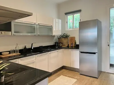 a kitchen with white cabinets and a stainless steel refrigerator at Madeira Breeze in Funchal