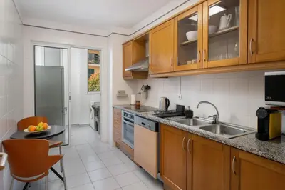 a kitchen with wooden cabinets and a sink at Madalenas III by An Island Apart in Funchal