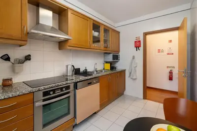 a kitchen with wooden cabinets and a stove top oven at Madalenas III by An Island Apart in Funchal