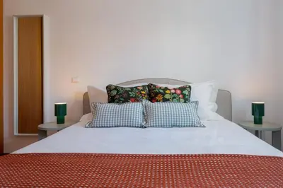 a bedroom with a bed with pillows and two tables at Madalenas III by An Island Apart in Funchal