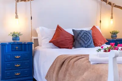 a bed with red pillows and a blue night stand at GuestReady - Idyllic vacation with stunning views in Caniço