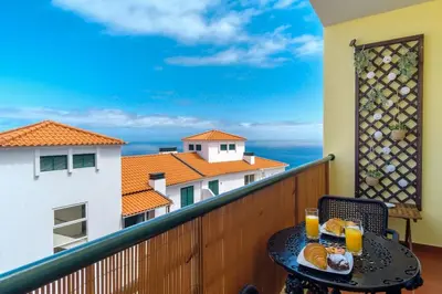 a table with bread and orange juice on a balcony at GuestReady - Idyllic vacation with stunning views in Caniço