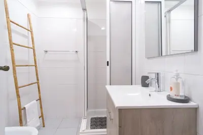 a white bathroom with a shower and a sink at GuestReady - Idyllic vacation with stunning views in Caniço