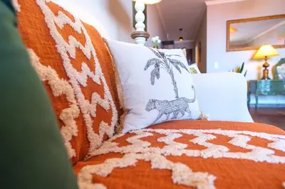 a couch with an orange and white blanket and pillows at GuestReady - Idyllic vacation with stunning views in Caniço