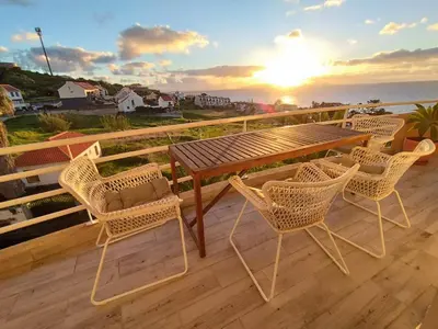 a table and chairs on a deck with a view of the ocean at Ocean View Terrace by GALMI in Santa Cruz