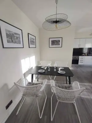 a dining table and chairs in a living room at Ocean View Terrace by GALMI in Santa Cruz