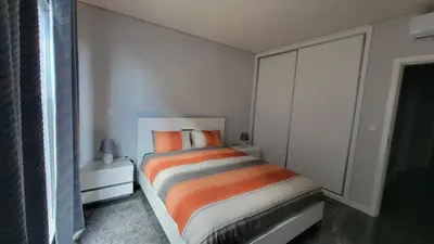 a bedroom with a bed with orange and white sheets at Villa Bacana Oasis in Estreito da Calheta