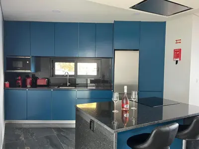 a blue kitchen with a counter and blue cabinets at Villa Bacana Oasis in Estreito da Calheta