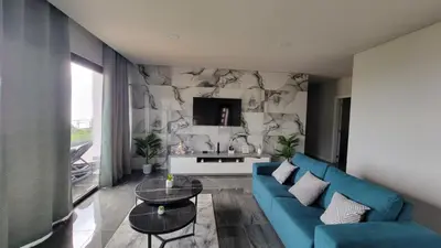 a living room with a blue couch and a tv at Villa Bacana Oasis in Estreito da Calheta