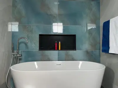 a white tub in a bathroom with a tile wall at Villa Bacana Oasis in Estreito da Calheta