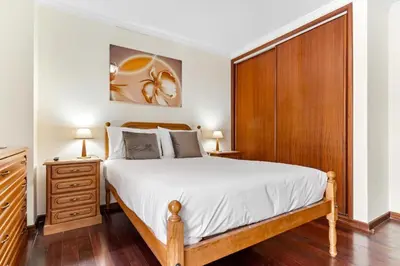 a bedroom with a large bed and a wooden cabinet at Ribeira Brava Studios - M in Ribeira Brava
