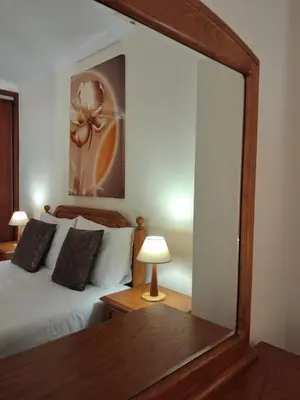a mirror in a bedroom with a bed and a lamp at Ribeira Brava Studios - M in Ribeira Brava