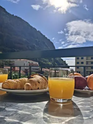a table with a glass of orange juice and pastries at Ribeira Brava Studios - J in Ribeira Brava