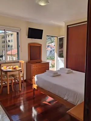 a bedroom with a bed and a table and a television at Ribeira Brava Studios - J in Ribeira Brava