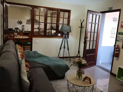 a living room with a couch and a table at Charming Retreat Machico - 5 min Praia & Centro B in Machico