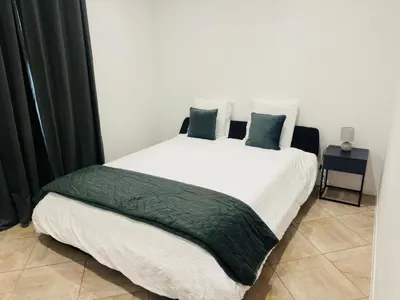 a bedroom with a large white bed with green pillows at Stylish 3-bedroom flat in Funchal in Funchal