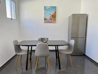 a dining room table with chairs and a refrigerator at Stylish 3-bedroom flat in Funchal in Funchal