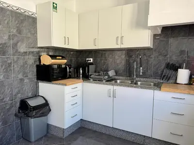 a kitchen with white cabinets and a sink at Stylish 3-bedroom flat in Funchal in Funchal