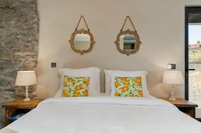 a bedroom with a bed with two lamps and mirrors at Villa Clementina | Cliffs&Ocean | Heated Pool in Prazeres