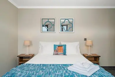 a bedroom with a bed with a blue blanket and two lamps at Villa Clementina | Cliffs&Ocean | Heated Pool in Prazeres