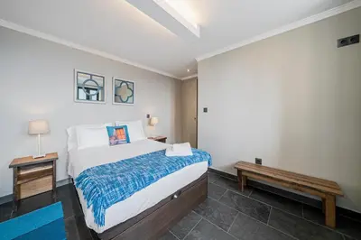 a bedroom with a large bed and a bench at Villa Clementina | Cliffs&Ocean | Heated Pool in Prazeres