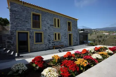 a building with a bunch of flowers in front of it at Villa Clementina | Cliffs&Ocean | Heated Pool in Prazeres