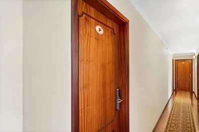 a wooden door with a clock on it next to a hallway at Ribeira Brava Studios - P in Ribeira Brava