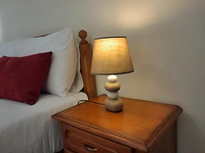 a lamp on a wooden table next to a bed at Ribeira Brava Studios - N in Ribeira Brava