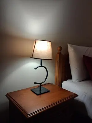 a lamp on a wooden table next to a bed at Ribeira Brava Studios - N in Ribeira Brava