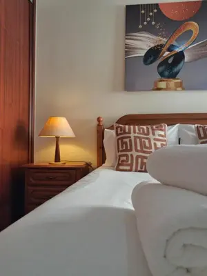 a bedroom with a white bed with a lamp on a night stand at Ribeira Brava Studios - L in Ribeira Brava