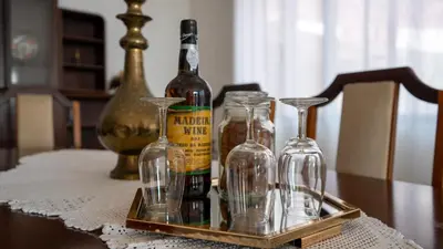 a tray with wine bottles and glasses on a table at Ideia Cottage - Sea View in Ribeira Brava