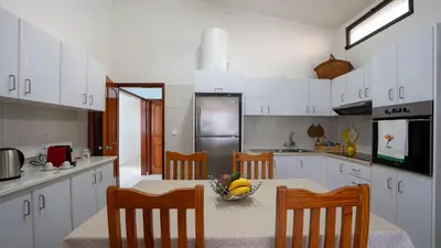 a kitchen with a table with a bowl of fruit on it at Ideia Cottage - Sea View in Ribeira Brava