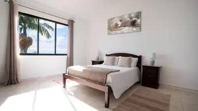 a bedroom with a bed and a large window at Ideia Cottage - Sea View in Ribeira Brava