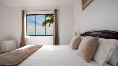 a bedroom with a white bed with a window at Ideia Cottage - Sea View in Ribeira Brava