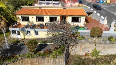 a yellow house with an orange roof at Ideia Cottage - Sea View in Ribeira Brava