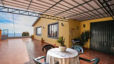 a dining room with a table and chairs and the ocean at Ideia Cottage - Sea View in Ribeira Brava