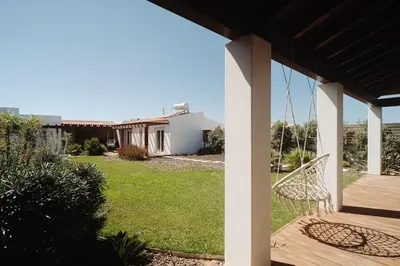 a porch with a swing and a yard at Family & Friends in Sagres