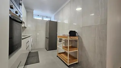 a small kitchen with a counter and a refrigerator at October Nest in Funchal