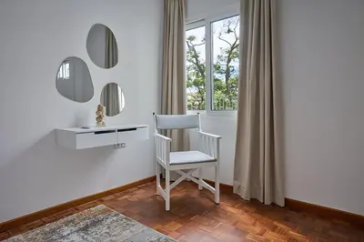 a white chair in a room with a desk and mirror at Jasmine Whisper by Elysian in Funchal