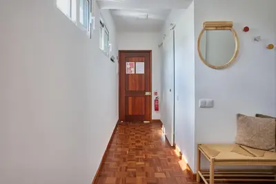 a hallway with a door and a chair and a mirror at Jasmine Whisper by Elysian in Funchal
