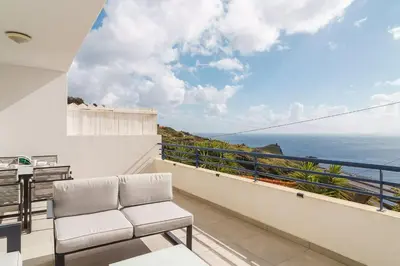 a balcony with two chairs and a view of the ocean at GuestReady - Relaxing moment in Caniço in Caniço