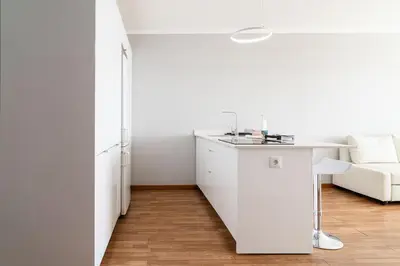 a white kitchen with a sink and a couch at GuestReady - Relaxing moment in Caniço in Caniço