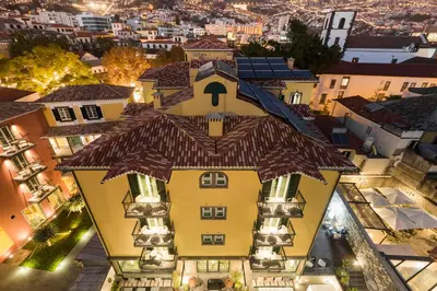 an aerial view of a yellow building with a roof at Castanheiro Boutique Hotel in Funchal