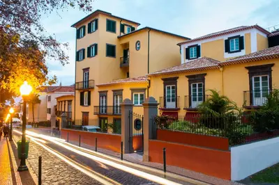 a row of houses on a street at dusk at Castanheiro Boutique Hotel in Funchal