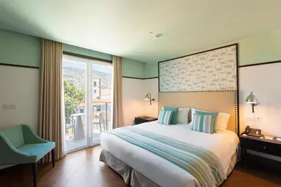 a hotel room with a bed and a balcony at Castanheiro Boutique Hotel in Funchal