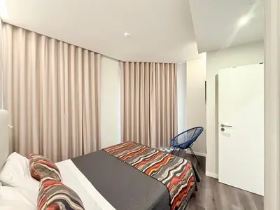 a bedroom with a bed and a chair in it at Gold Center Funchal 104 in Funchal