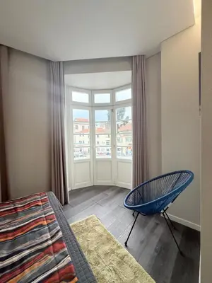a bedroom with a bed and a chair and a window at Gold Center Funchal 104 in Funchal