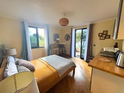a room with a bed and a kitchen with a table at Bella Vista Studio in Canhas